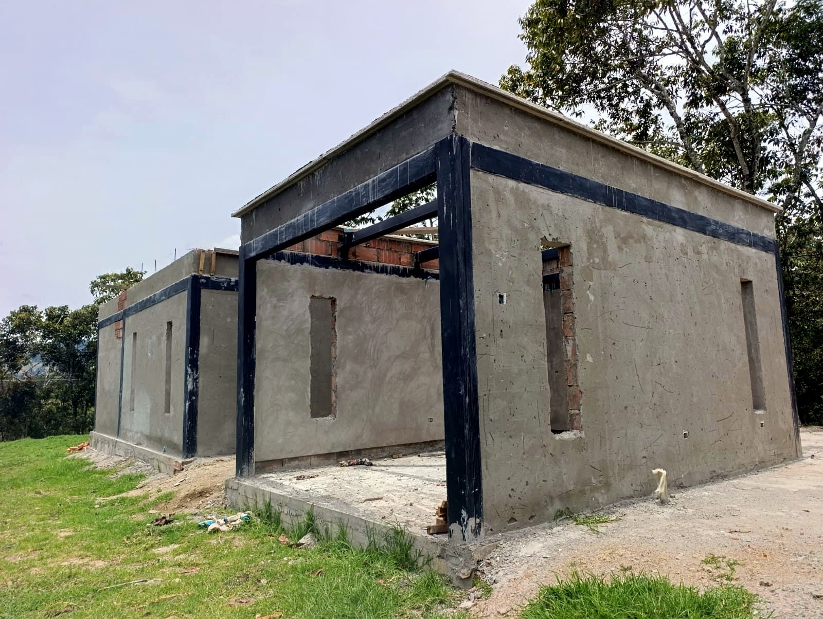 Fachada posterior pañetada con estructura metálica a la vista
