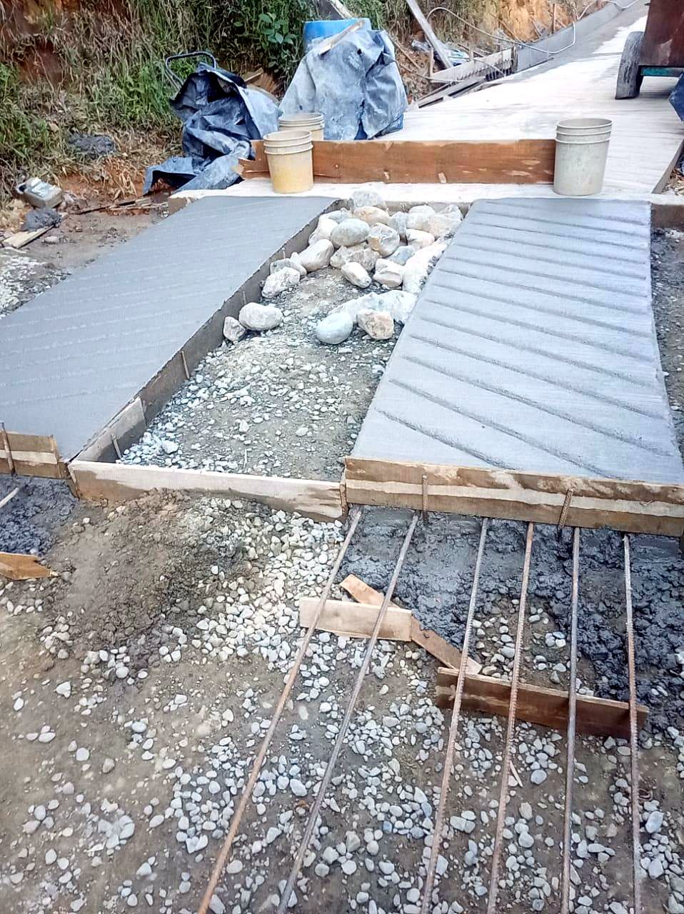 Placa huella en concreto recién vaciada con rieles y ciclópeo