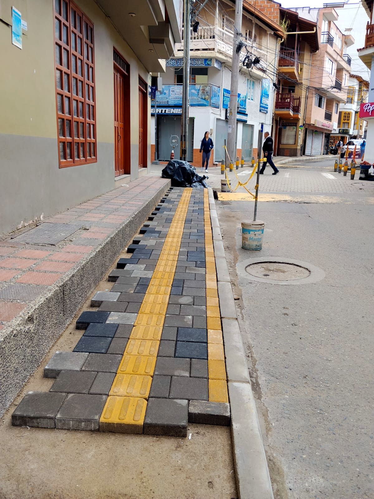 Andén en adoquín gris y negro con loseta táctil amarilla y bordillo en concreto, Marinilla